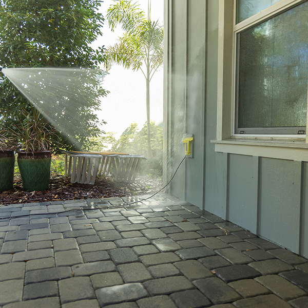 pressure washing professional washing exterior of gray home